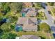 Aerial view showcasing a residence with a pool, enclosed by a screened enclosure, and a lush green lawn at 3769 Fiano Dr, Port Orange, FL 32129