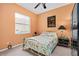 Bedroom with floral bedding, black and gold nightstands, and orange walls at 3769 Fiano Dr, Port Orange, FL 32129