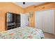 Guest bedroom with floral bedding, ample closet space, and orange walls at 3769 Fiano Dr, Port Orange, FL 32129