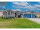 Inviting home exterior with a well-maintained lawn and blue double garage doors at 3769 Fiano Dr, Port Orange, FL 32129