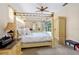 Large main bedroom with a four-poster bed, carpeted floors, and a pool view at 3769 Fiano Dr, Port Orange, FL 32129