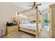 Main bedroom with four-poster bed, pool view, and ensuite bathroom access at 3769 Fiano Dr, Port Orange, FL 32129