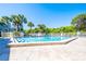 Community pool with spacious deck and surrounding palm trees at 4200 Sun Village Ct # 33D, New Smyrna Beach, FL 32169