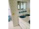 Bathroom with dual sinks, light blue vanity and patterned wallpaper at 4255 S Atlantic Ave, Port Orange, FL 32127