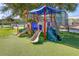 Community playground with shaded play structure, slides, and artificial turf at 4324 Candlewood Ln, Ponce Inlet, FL 32127