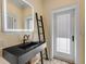 Modern bathroom with black vessel sink, illuminated mirror, and patterned floor at 4946 Halifax Dr, Port Orange, FL 32127