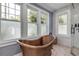 Copper bathtub and walk-in shower with hexagon tile floor in a stylish bathroom at 4946 Halifax Dr, Port Orange, FL 32127