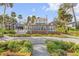 Two-story brick home with white trim, gated entrance, and palm trees at 4946 Halifax Dr, Port Orange, FL 32127