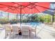 Outdoor patio dining area with large red umbrella near pool at 4946 Halifax Dr, Port Orange, FL 32127