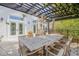 Outdoor dining area with pergola, lush greenery, and seating for ten at 4946 Halifax Dr, Port Orange, FL 32127