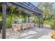 Outdoor dining area with pergola, lush greenery, and seating for ten at 4946 Halifax Dr, Port Orange, FL 32127