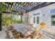 Outdoor dining area with pergola, lush greenery, and seating for ten at 4946 Halifax Dr, Port Orange, FL 32127