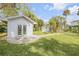 White detached studio with double doors in a lush garden setting at 4946 Halifax Dr, Port Orange, FL 32127