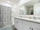 Double vanity bathroom with shower and patterned curtain at 815 Sky Haven Way, New Smyrna Beach, FL 32168