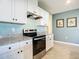 Modern kitchen with white cabinets, granite countertops, and stainless steel appliances at 815 Sky Haven Way, New Smyrna Beach, FL 32168