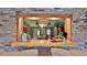 Bar area with granite countertop and a view into the kitchen through a brick archway at 839 Fairway Dr, New Smyrna Beach, FL 32168