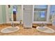 Dual vanity bathroom with granite countertops, white cabinets, and mirrors at 839 Fairway Dr, New Smyrna Beach, FL 32168