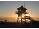 Lifeguard stand silhouette against a beautiful golden sunrise on the beach at 839 Fairway Dr, New Smyrna Beach, FL 32168