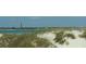 Coastal view with sand dunes, beach grass, and distant lighthouse at 839 Fairway Dr, New Smyrna Beach, FL 32168