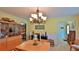 Dining area with table, hutch, and chandelier, adjacent to the kitchen and foyer at 839 Fairway Dr, New Smyrna Beach, FL 32168