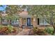 Charming brick home with blue door, landscaped walkway, and lush greenery at 839 Fairway Dr, New Smyrna Beach, FL 32168