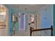 Hallway with teal walls, carpeting, and wooden railing leading to the bedrooms at 839 Fairway Dr, New Smyrna Beach, FL 32168