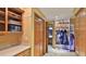 Laundry room with wooden cabinets, storage shelves, and access to a hallway at 839 Fairway Dr, New Smyrna Beach, FL 32168