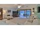 Bright living room with white furniture, large windows, and a view of the pool at 839 Fairway Dr, New Smyrna Beach, FL 32168