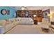 Living room with white sectional sofa, built-in bookshelves, and tiled floor at 839 Fairway Dr, New Smyrna Beach, FL 32168