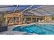 Screened-in pool and spa with sitting area and view of golf course at 839 Fairway Dr, New Smyrna Beach, FL 32168