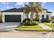 Modern home with white exterior, dark garage door, and landscaped yard at 142 Sandpiper Ridge Dr, Ormond Beach, FL 32176