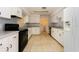 Bright kitchen featuring white cabinets, black appliances, and tile flooring at 5025 E Lake Mary Blvd, Sanford, FL 32771