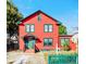 Two-story red house with green trim and picket fence at 415 Braddock Ave, Daytona Beach, FL 32118