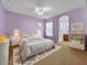 Main bedroom with a plush bed, en-suite bathroom, and soft color scheme at 5244 Oakbourne Ave, Davenport, FL 33837