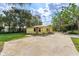 Yellow house exterior with a large yard and driveway at 14650 Liberty St, Orlando, FL 32826