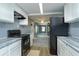 Modern kitchen with white cabinets, granite countertops, and black appliances at 14650 Liberty St, Orlando, FL 32826