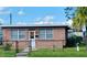 Brick home with a well-maintained lawn and a fenced yard at 1023 W Gore W St, Orlando, FL 32805