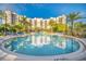 Inviting resort-style pool with palm trees and building view at 14501 Grove Resort Ave # 1430, Winter Garden, FL 34787
