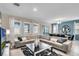 Open concept living room with sectional sofa and access to patio at 5288 Oakbourne Ave, Davenport, FL 33837