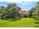 Brick house with a large front yard, landscaping, and a tree at 10980 Jim Edwards Rd, Haines City, FL 33844
