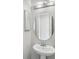 Small bathroom with pedestal sink and circular mirror at 1554 Fairview Cir, Kissimmee, FL 34747