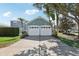 Two-car garage with white doors and a long driveway at 1554 Fairview Cir, Kissimmee, FL 34747