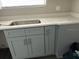 Modern kitchen with gray cabinets and stainless steel sink at 2512 Woodgate Blvd # 104, Orlando, FL 32822