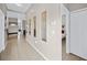 Clean hallway with tile flooring and mirrors adding brightness to the space at 165 Captain Hook Way, Davenport, FL 33837
