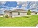 View of the house's back, highlighting a spacious yard and a side patio at 1278 Tagliamento Ln, Haines City, FL 33844