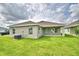 View of house from behind, showing covered patio and grassy yard at 1278 Tagliamento Ln, Haines City, FL 33844