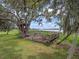 Lakefront treehouse with a platform and bench seating, shaded by live oaks at 260 Deer Isle Dr, Winter Garden, FL 34787