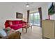 Living room with red couch, wood coffee table, and access to a balcony at 1375 Tuscana Ln # 1308, Davenport, FL 33896