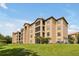 Tan three-story building with balconies and green space at 1375 Tuscana Ln # 1308, Davenport, FL 33896