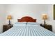Simple bedroom with a striped bedspread and wood headboard at 1375 Tuscana Ln # 1308, Davenport, FL 33896